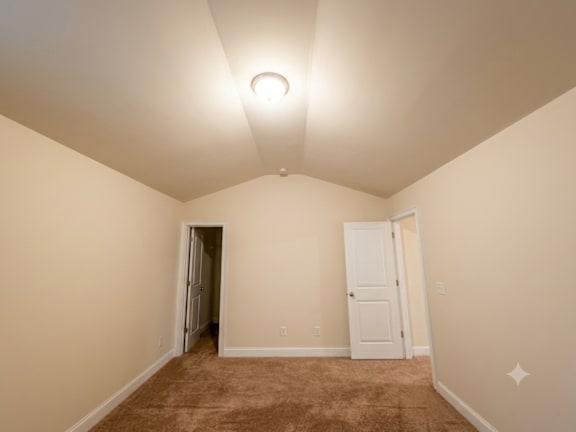 A room with a carpeted floor and a single light fixture on the ceiling.