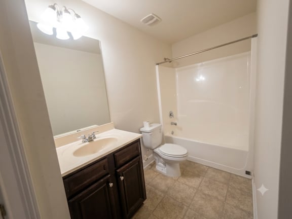 A bathroom with a sink, toilet, and bathtub.