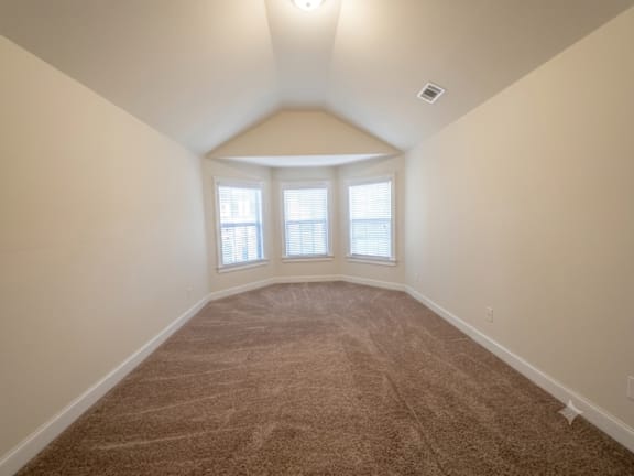A room with carpeted floor and a window.