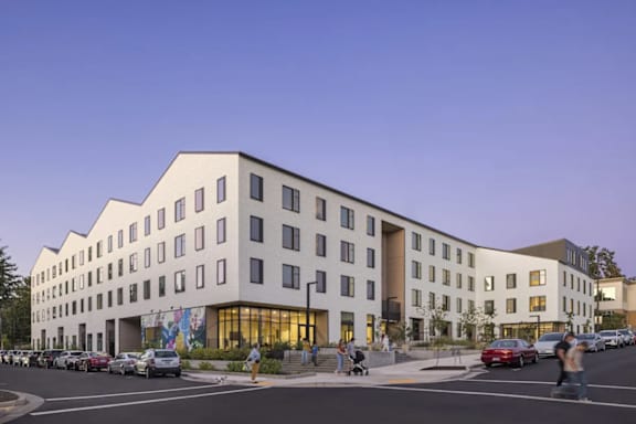 A modern building with a parking lot in front of it.