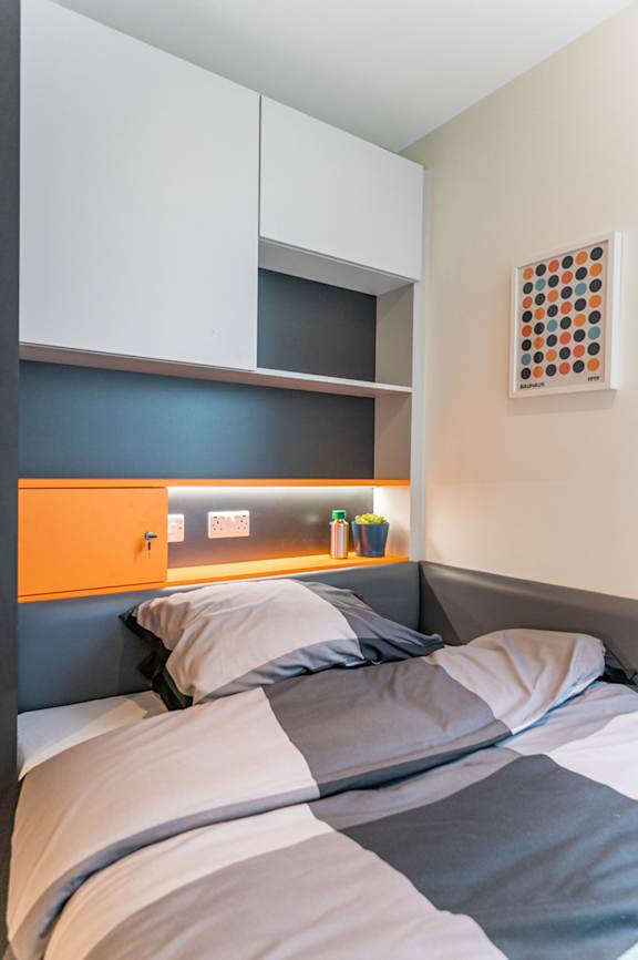 a bedroom with a bed and a blue and white headboard