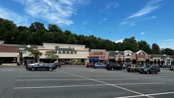 a parking lot filled with cars in front of a shopping center