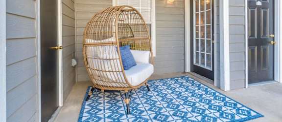 a hammock chair on the front porch of a house