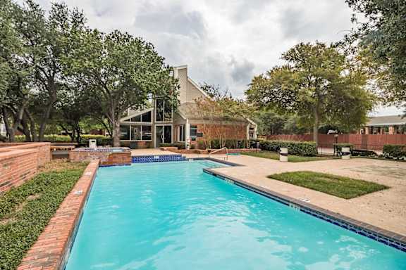 A swimming pool in a backyard with a house in the background.