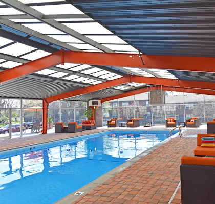 A large indoor swimming pool with orange seating.