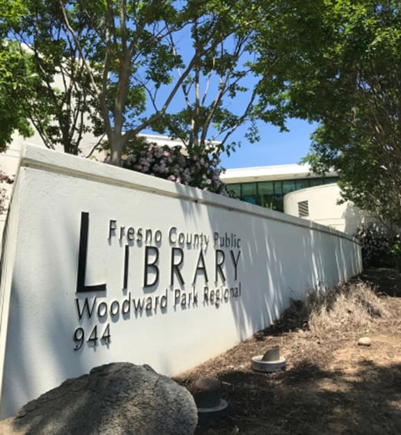 White sign for Fresno County Library, Le Provence at the Dominion, CA, 93720