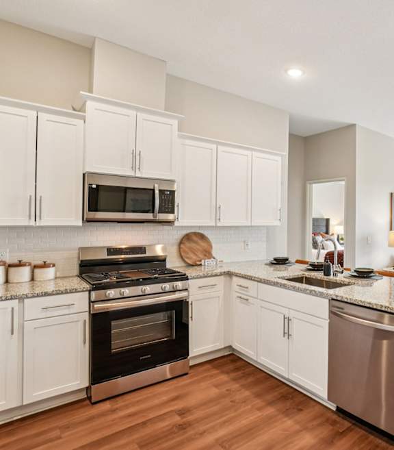 A modern kitchen with white cabinets and stainless steel appliances.