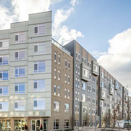 an apartment building on a city street with a red car