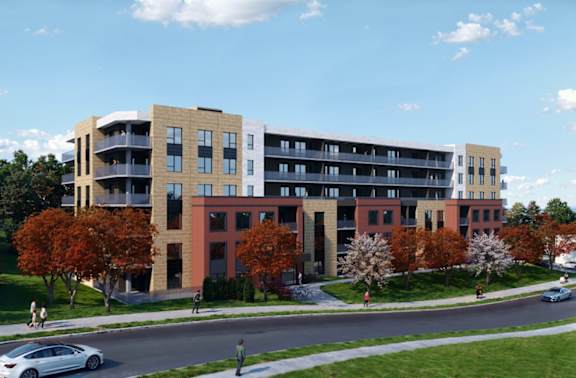 A modern apartment building with balconies and green lawns