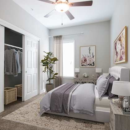 A bedroom with a bed, nightstand, and a ceiling fan.