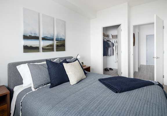 a bedroom with a bed and pillows and a closet