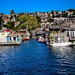 A body of water with boats and houses in the background.