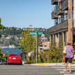 A woman in a purple shirt is crossing the street.