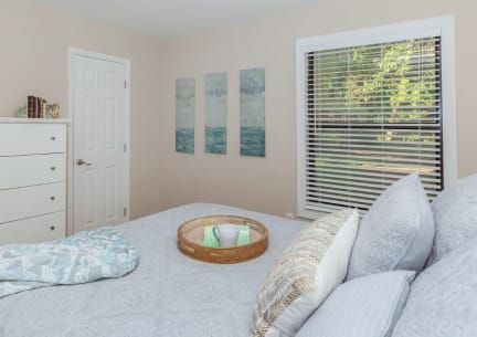 a bedroom with a bed and a window with blinds