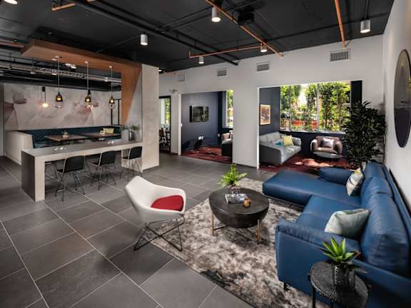 A clubhouse with a blue couch, a white chair, and a potted plant.