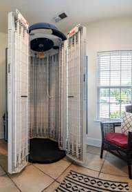 A room with a tanning booth and a chair at Puller Place Apartments, Jacksonville, NC, 28546