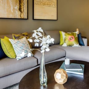 a living room with a couch and a table with flowers