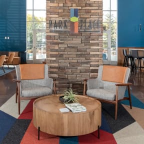 a seating area with chairs and a table in front of a stone fireplace