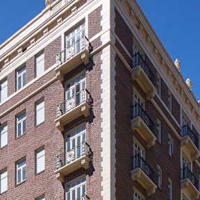 A red brick building with balconies on the second floor.