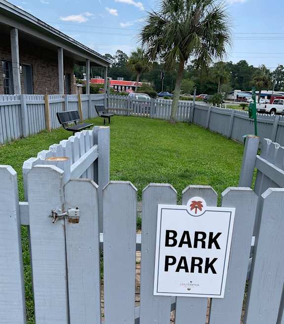 a white fence with a bark park sign on it