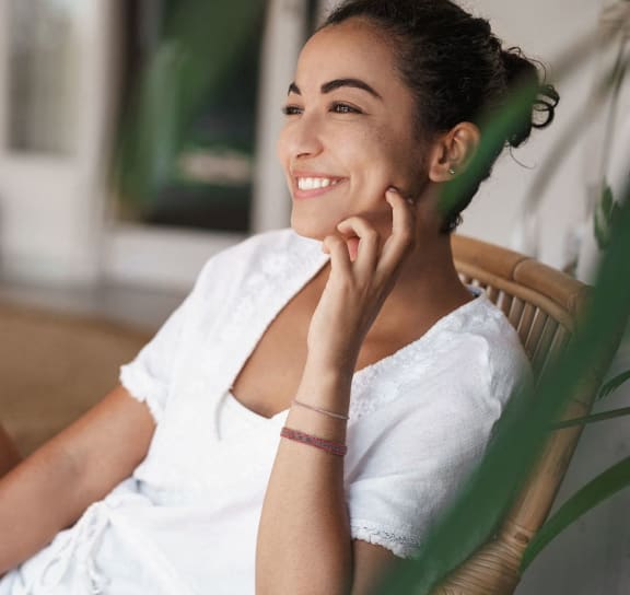 a woman sitting in a chair with her hand on her cheek