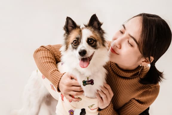 a woman is holding a dog with her face