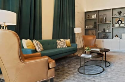 A living room with a green couch, a brown chair, and a coffee table.
