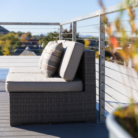 a couch with pillows on a deck overlooking a pool