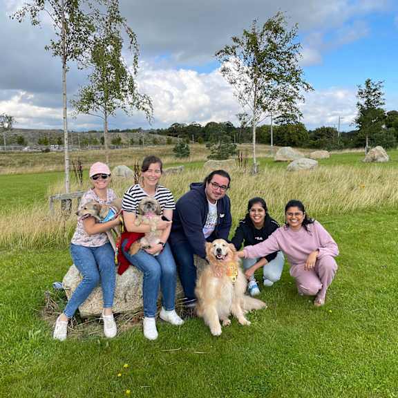 A group of people are sitting on a rock with a dog in front of them at Cherrywood Apartments, D18 VY3V, DUBLIN 18