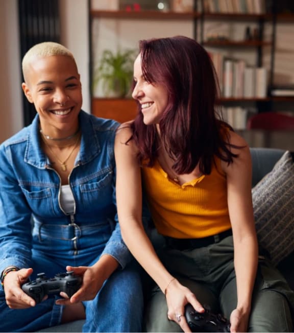 a woman and a young man sitting on a couch playing video games