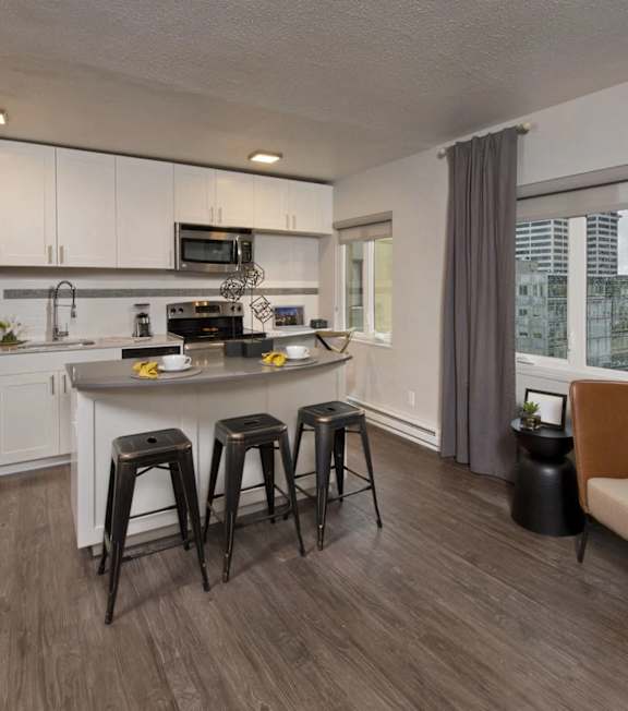 A kitchen with white cabinets and a grey countertop.