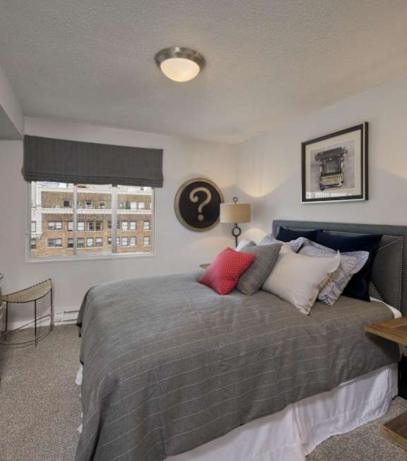 A bedroom with a large bed and a flat screen TV mounted on the wall.