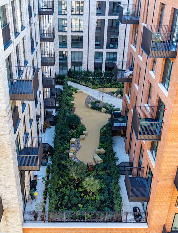 A courtyard surrounded by brick buildings with balconies.
