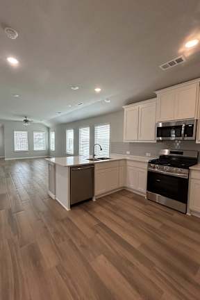 A Kitchen With Wooden Floor at Cottages at Beltmill Apartments, Saginaw, Texas