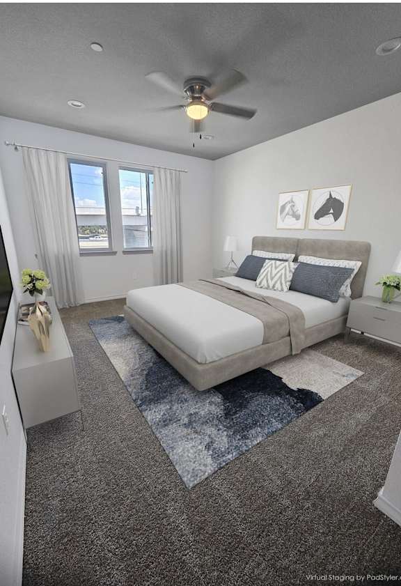 A bedroom with a large bed, a television, and a ceiling fan.