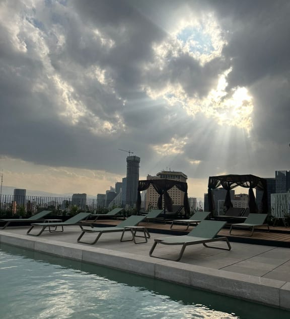 a swimming pool with a city skyline in the background
