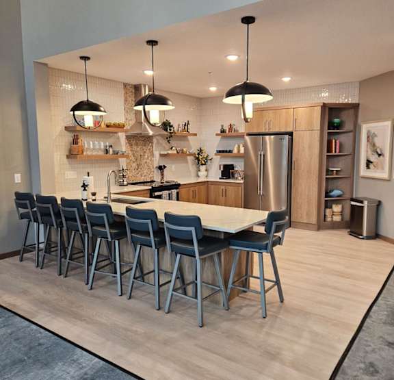 A modern kitchen with a long table and chairs.