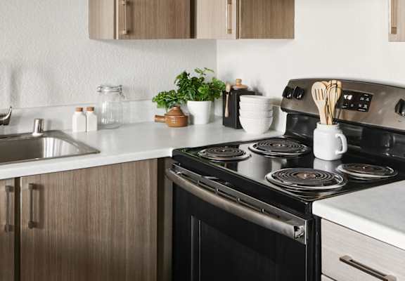 a kitchen with wooden cabinets and a black stove top oven