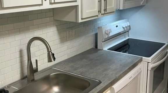 a kitchen with a sink and white cabinets