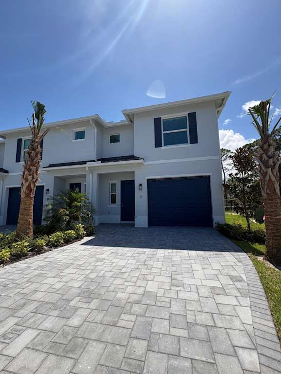 A modern two-story house with a driveway in front.