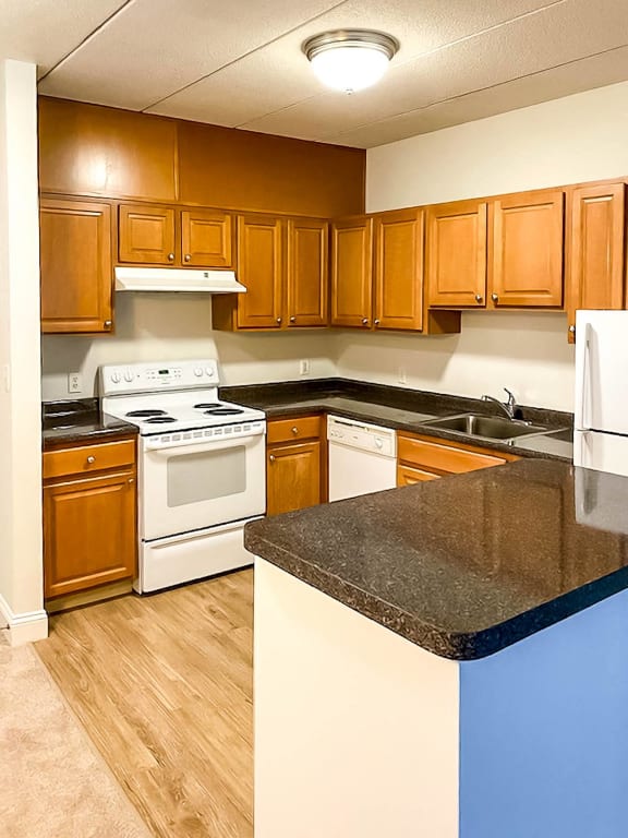 a kitchen with white appliances and wooden cabinets