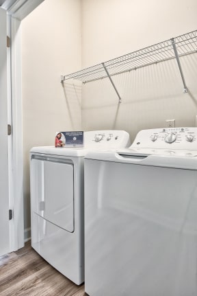 Two white washing machines in a laundry room.