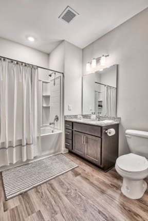 A bathroom with a toilet, sink, and shower.
