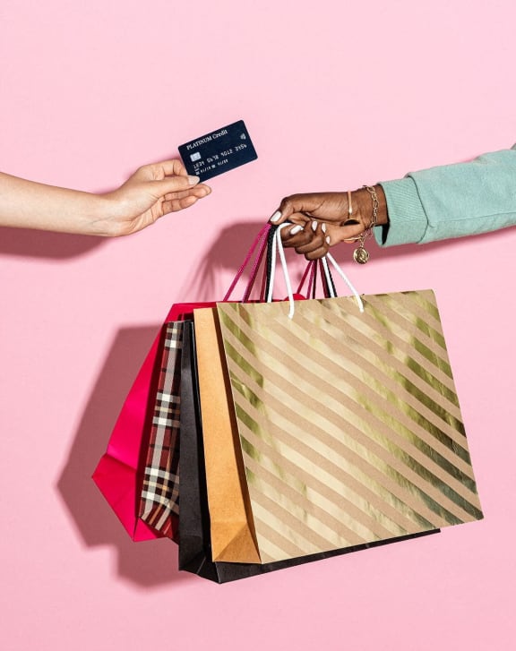 a person holding shopping bags and a credit card