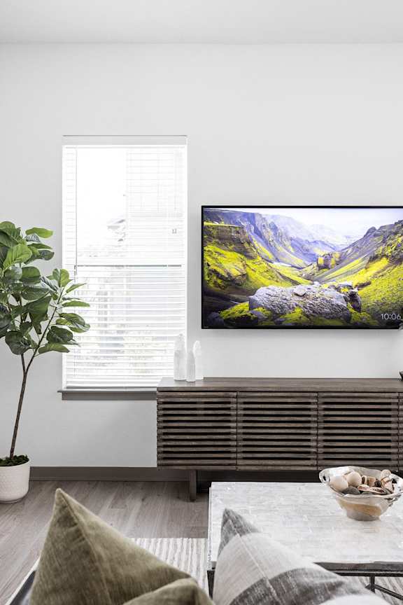 the frame hanging on a wall in a living room with at Slate at Fishers District, Fishers, IN