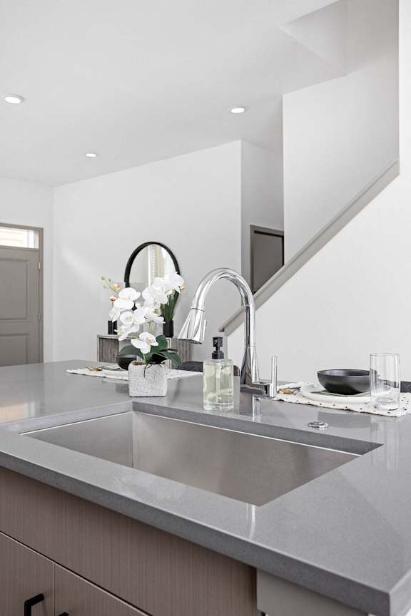 a kitchen counter with a sink and a mirror at Slate at Fishers District, Fishers, IN
