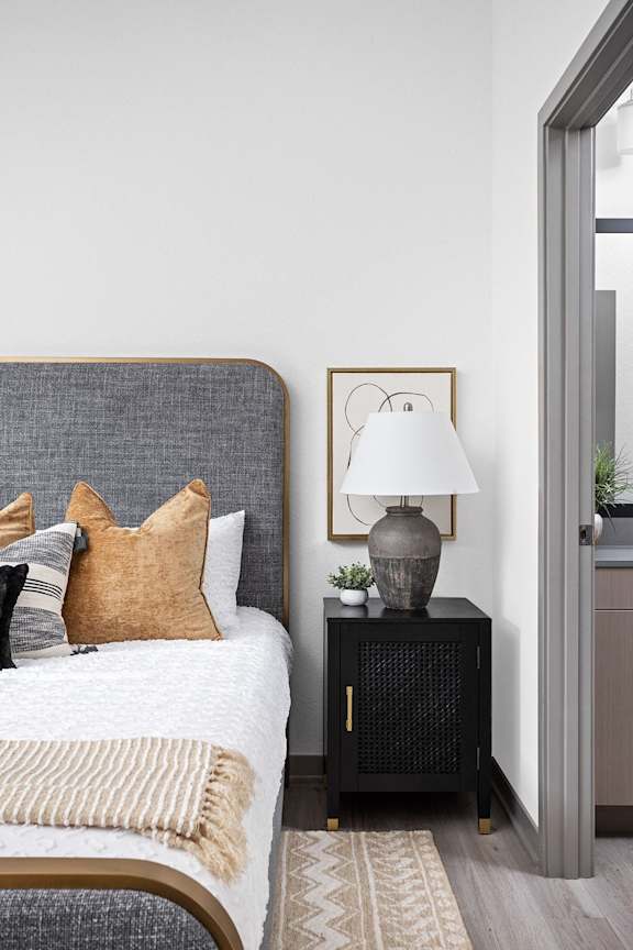 a bedroom with a bed and a nightstand with a lamp at Slate at Fishers District, Fishers, IN