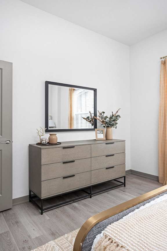 a bedroom with a bed and a dresser with a mirror  at Slate at Fishers District, Fishers, 46037