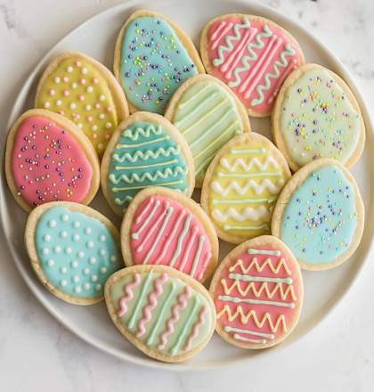 a white plate filled with decorated easter cookies