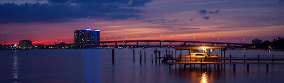 A boat is docked at a pier in the evening.